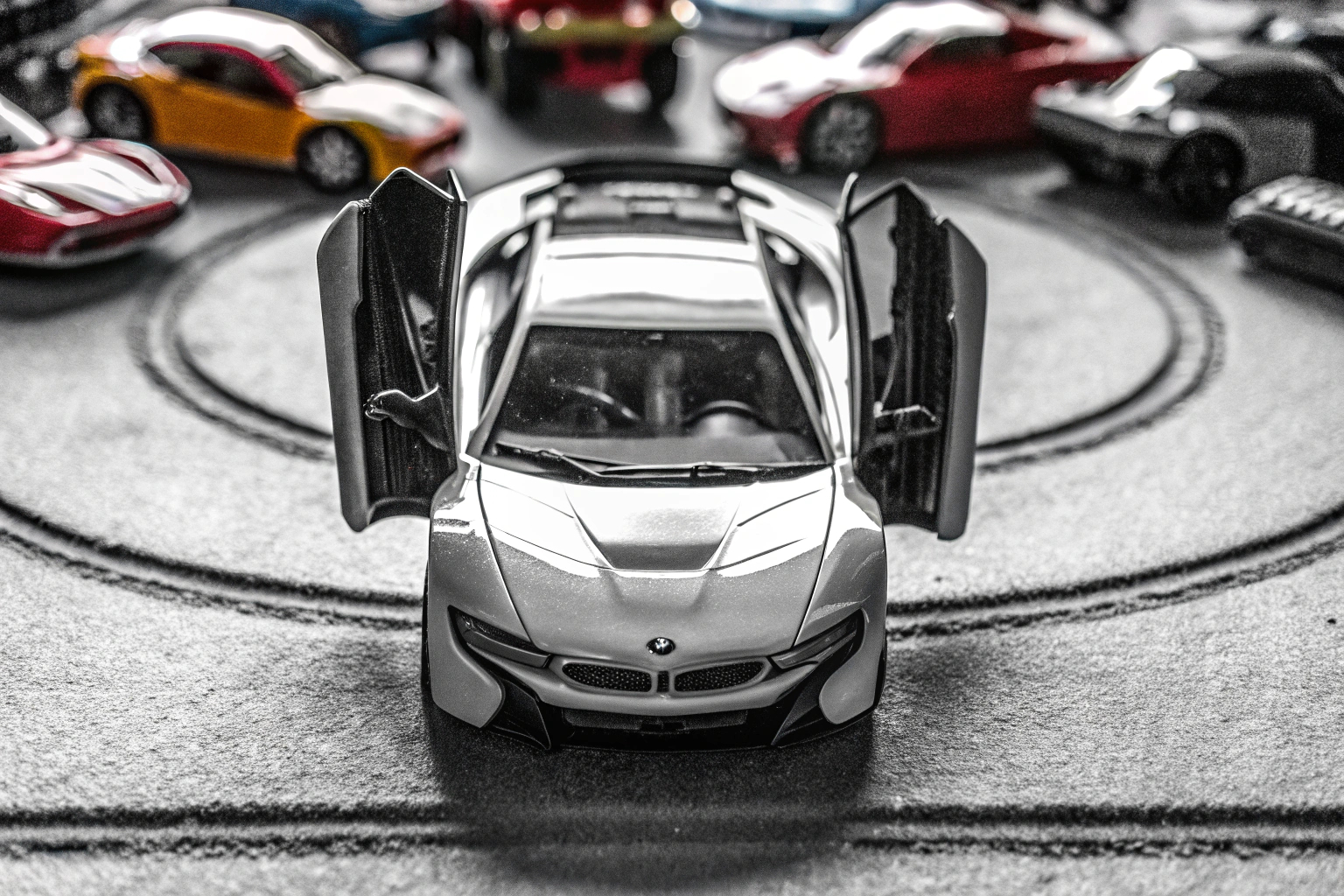 Das BMW i8 Polizeiauto zeigt seine Flügeltüren, umgeben von anderen Spielzeugautos. BMW i8 Polizeiauto mit Flügeltüren