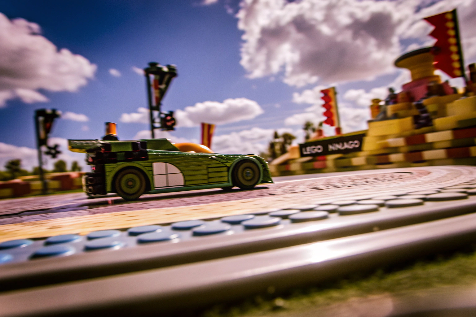 Der LEGO NINJAGO Lloyds Actionflitzer in voller Fahrt, bereit für ein rasantes Rennen auf der LEGO Rennstrecke. LEGO NINJAGO Lloyds Actionflitzer in Aktion