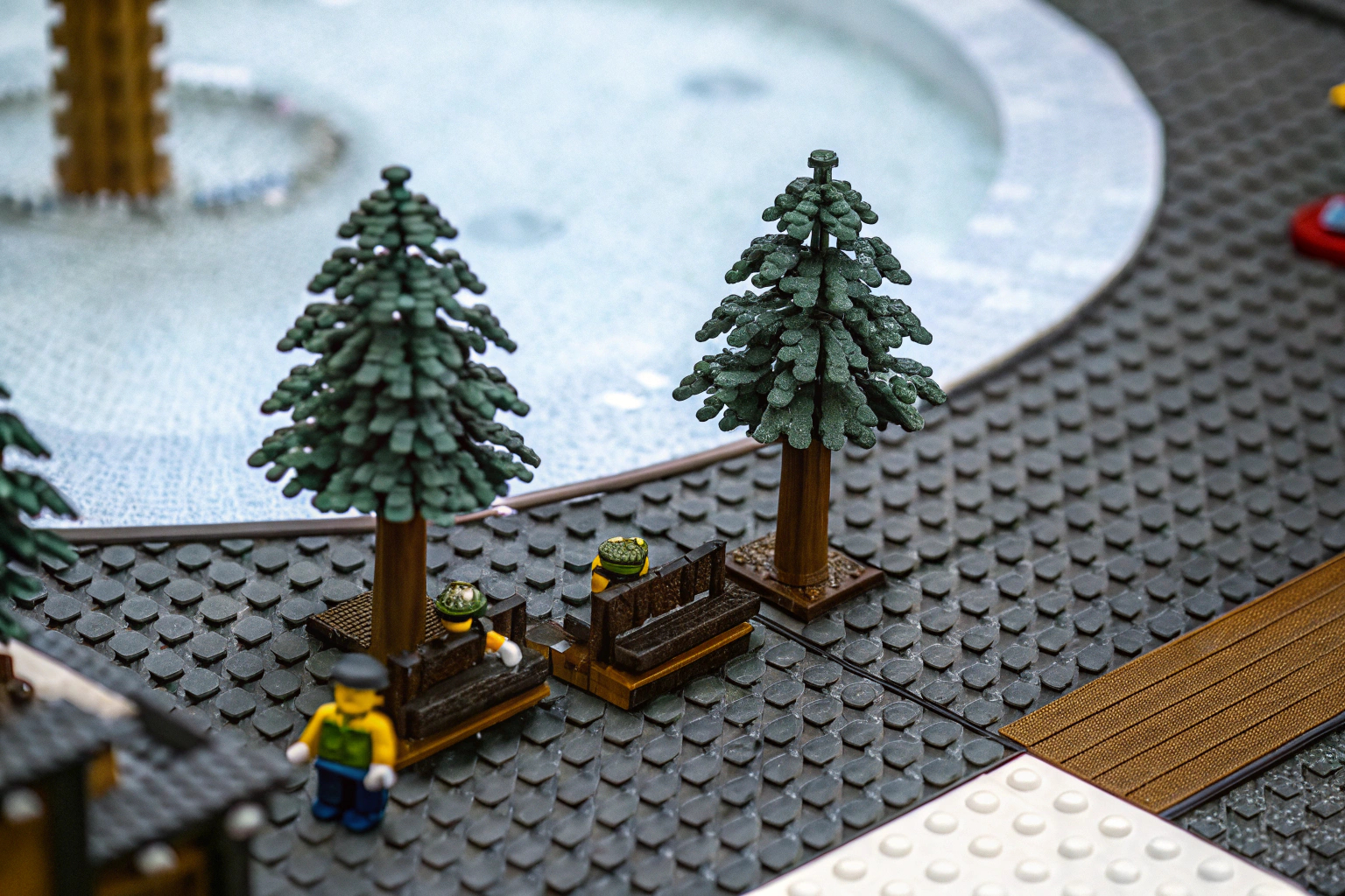 Detailaufnahme eines LEGO-Parks mit Bäumen und Bänken. LEGO Park