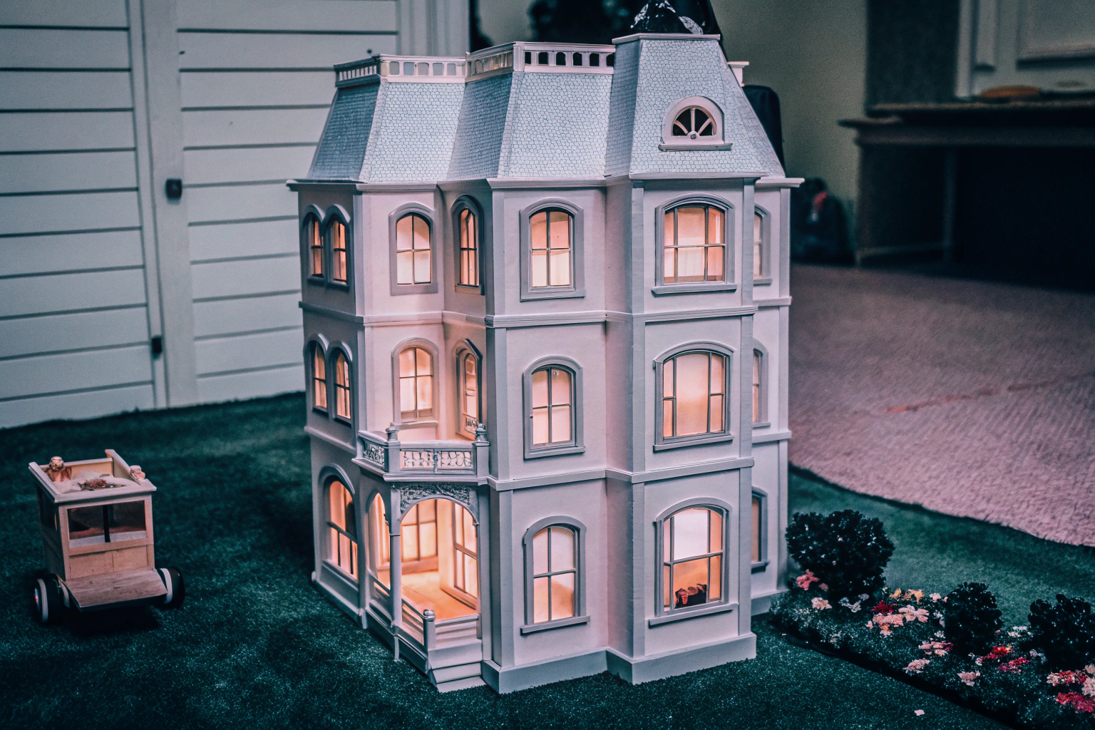 Detailaufnahme eines mehrstöckigen Puppenhauses mit leuchtenden Lichtern und funktionierendem Aufzug. Puppenhaus mit Lichtern und Aufzug
