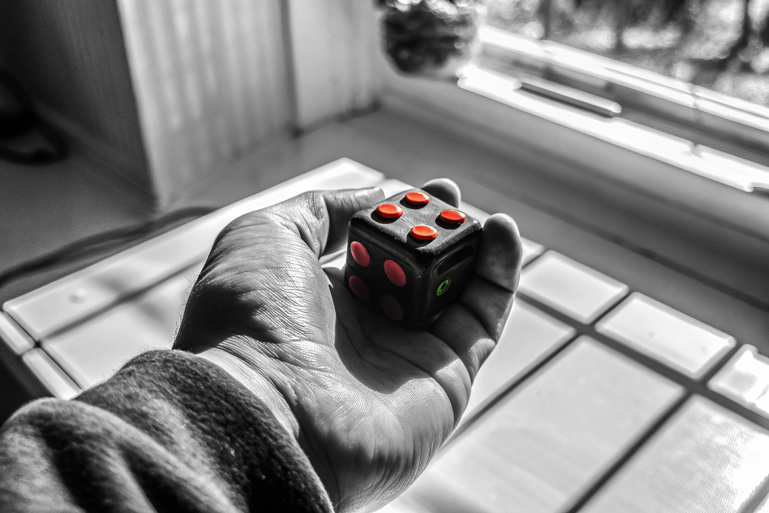 Ein Fidget Cube in der Hand eines Erwachsenen, der zur Stressreduzierung verwendet wird. Fidget Cube zur Stressreduktion