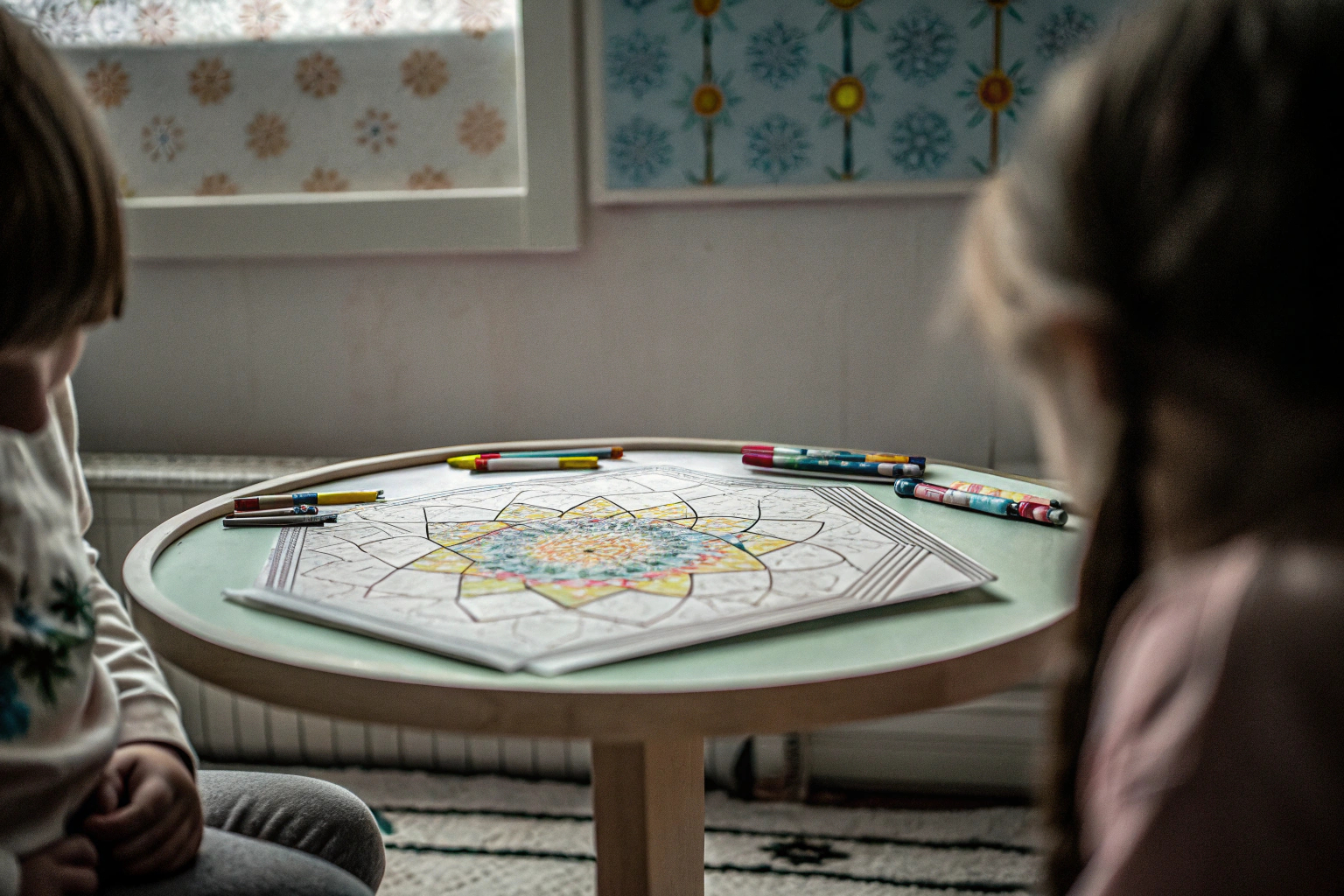 Ein Kind, das mit dem Ravensburger Spiral-Designer farbenfrohe Mandalas zeichnet. Kind zeichnet mit Spiral-Designer
