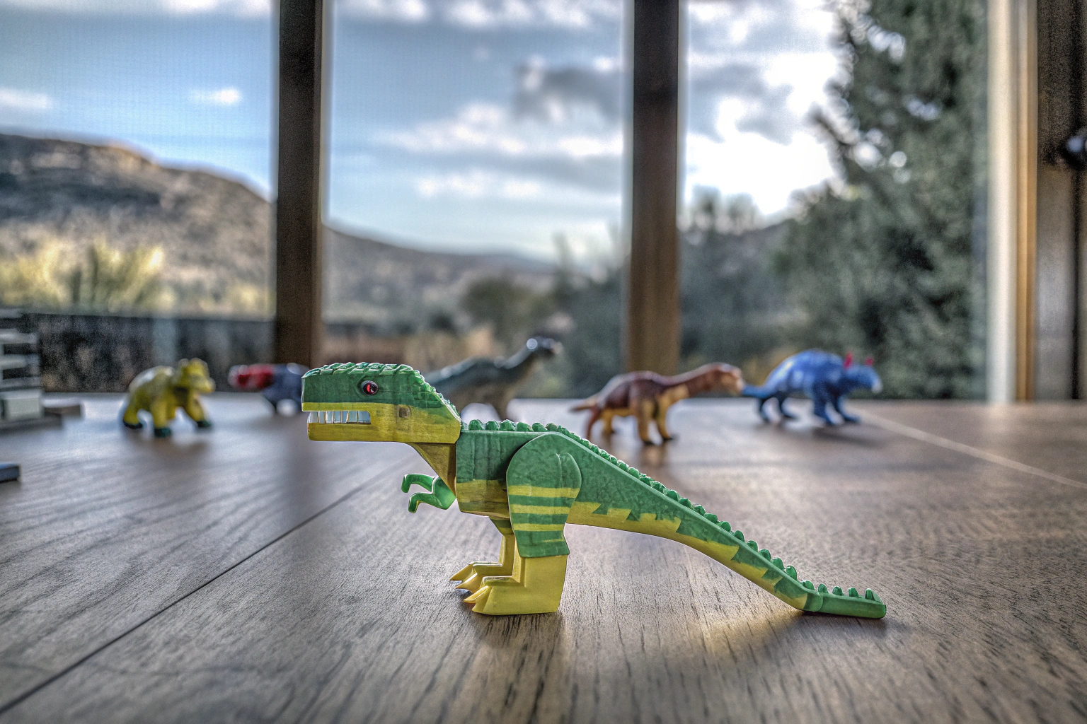 Ein Kind, das stolz seinen selbst gebauten LEGO T-Rex vorführt, während andere Dinosaurierfiguren im Hintergrund zu sehen sind. Kind mit LEGO T-Rex