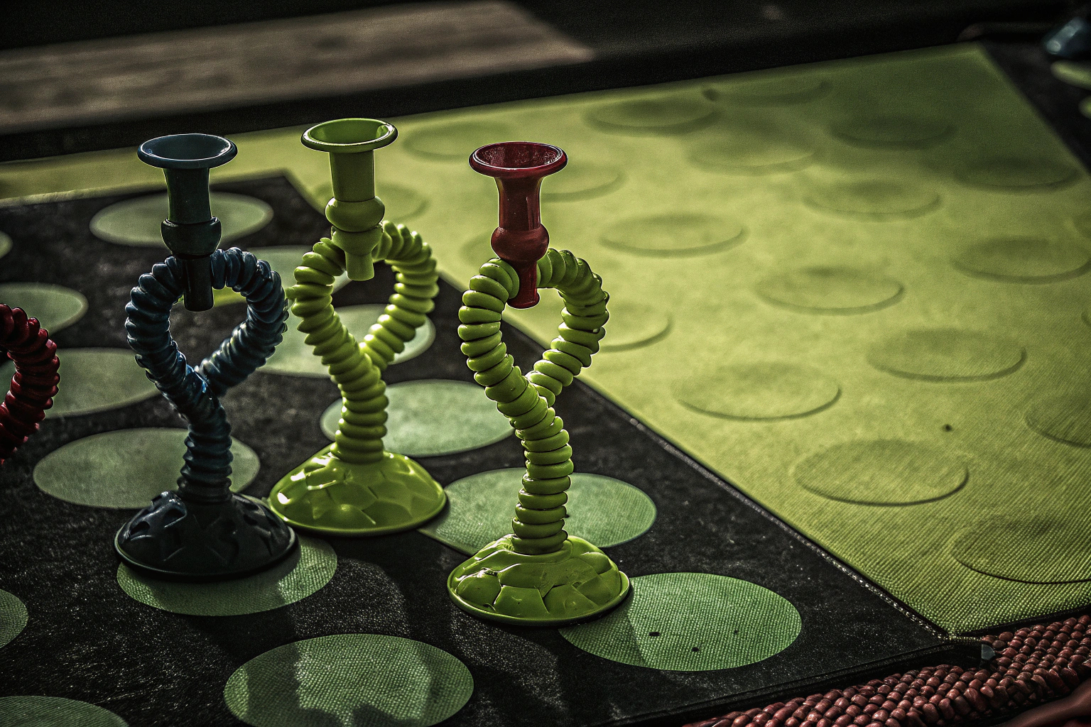 Ein Kind spielt mit dem ARROMI Saugnapf Spielzeug, das in verschiedenen Formen gedreht und fixiert ist. Kind spielt mit ARROMI Saugnapf Spielzeug