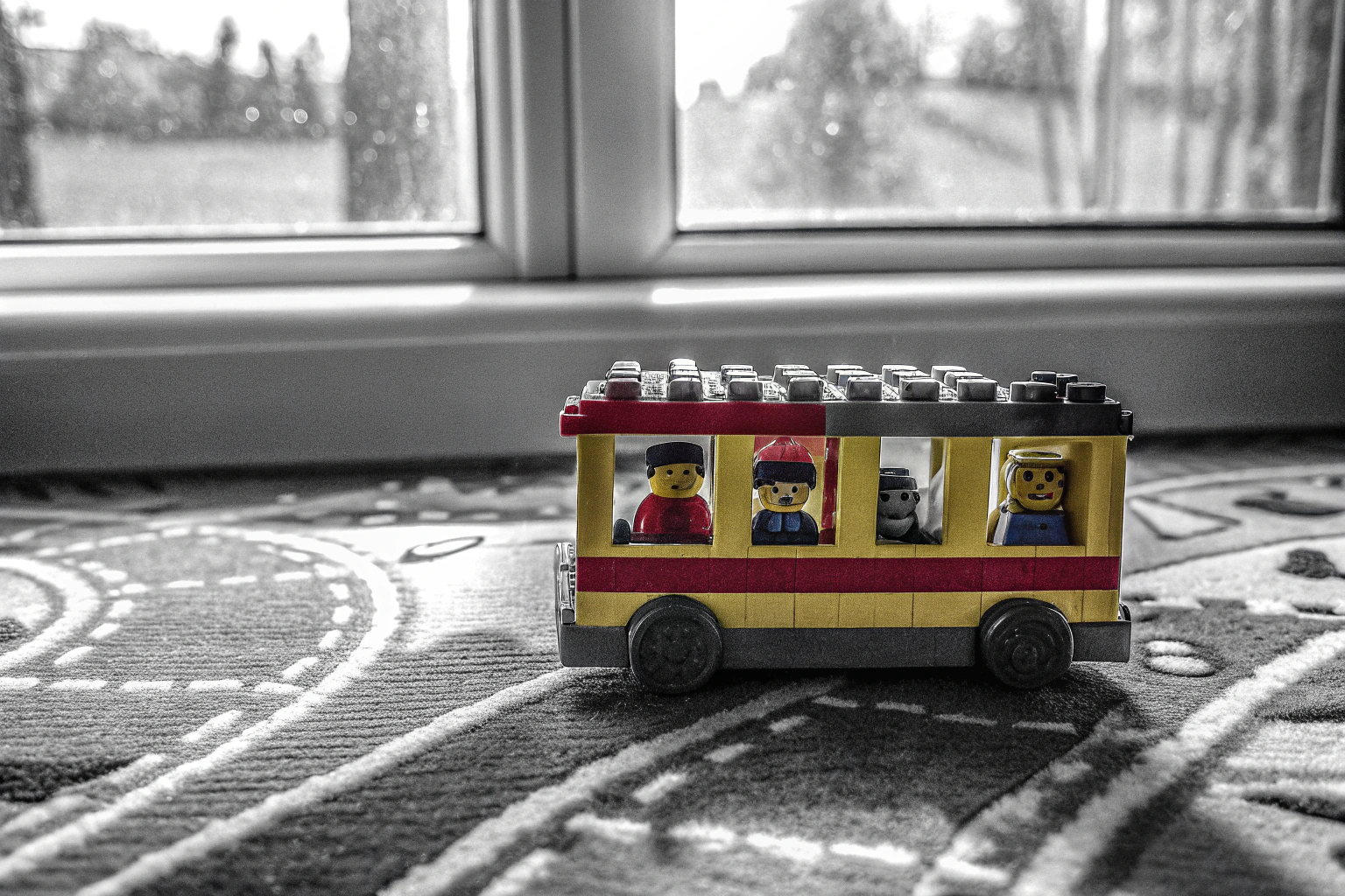 Ein Kind spielt mit dem LEGO DUPLO Busspielzeug und interagiert mit den Figuren. Kind spielt mit LEGO DUPLO Bus