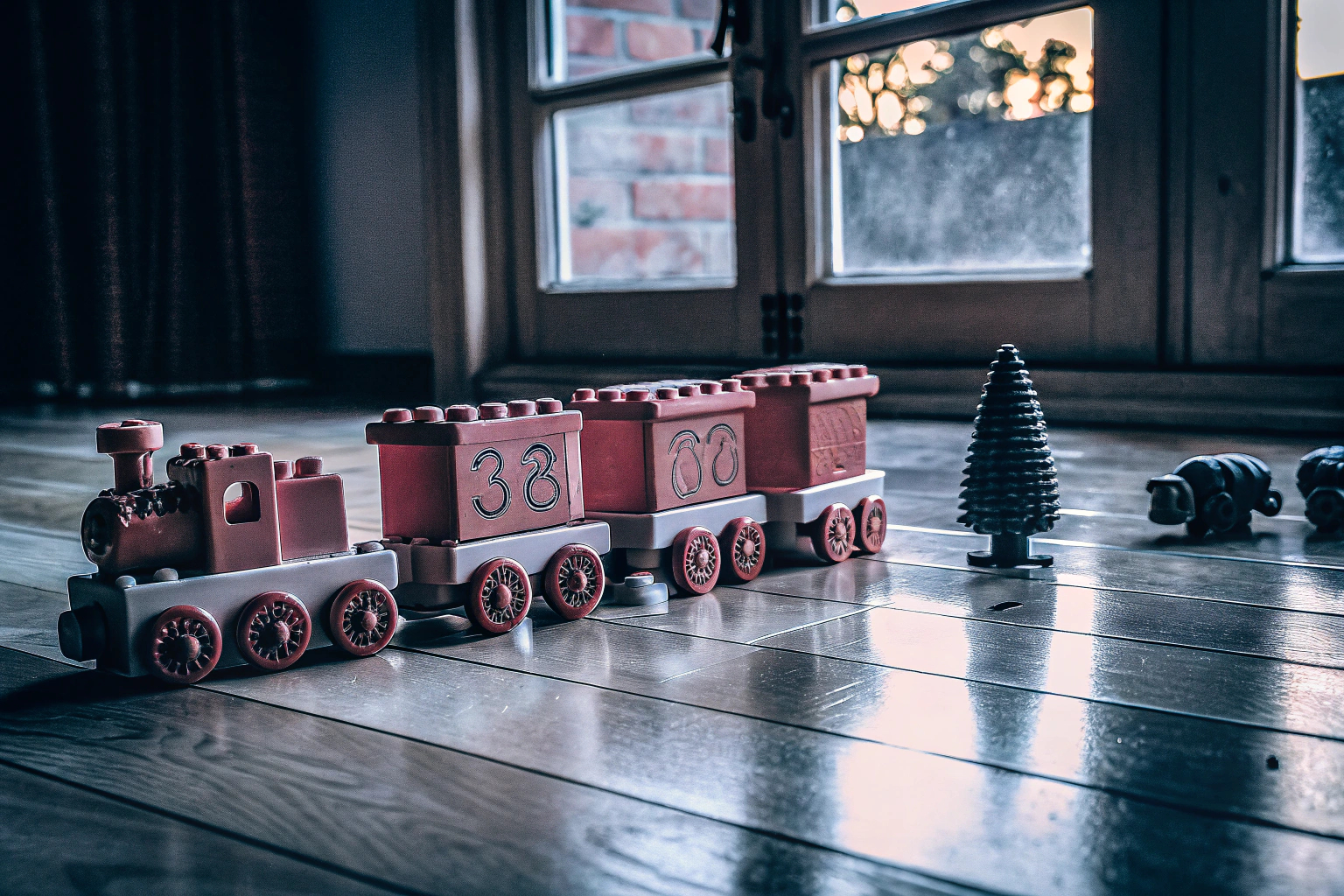 Ein Kind spielt mit dem LEGO DUPLO Zahlenzug auf einem Holzboden. LEGO DUPLO Zahlenzug