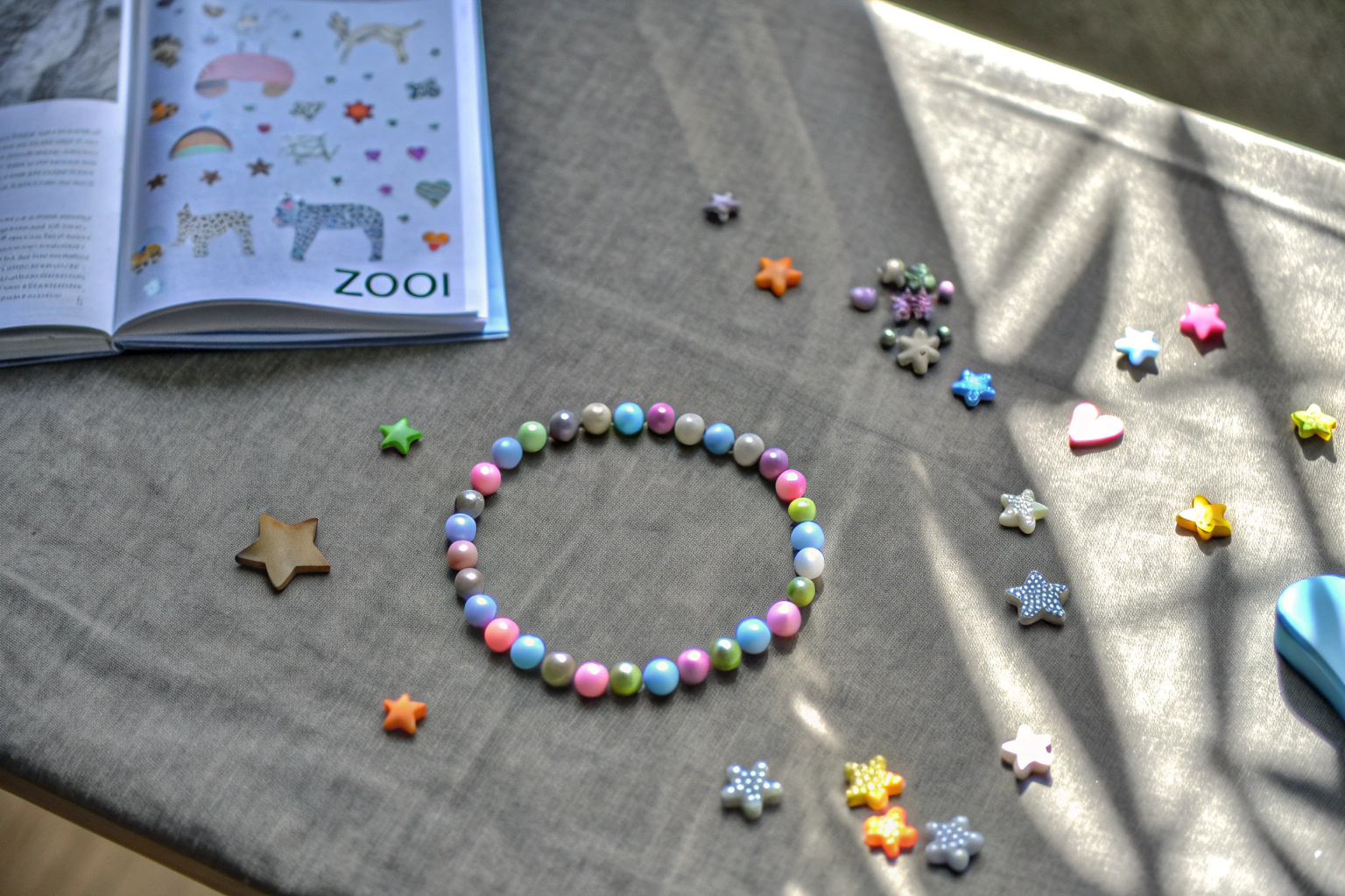 Ein Mädchen gestaltet ein Armband mit bunten Perlen und Charms aus dem ZOOI Bastelset. Armbandgestaltung mit ZOOI Set