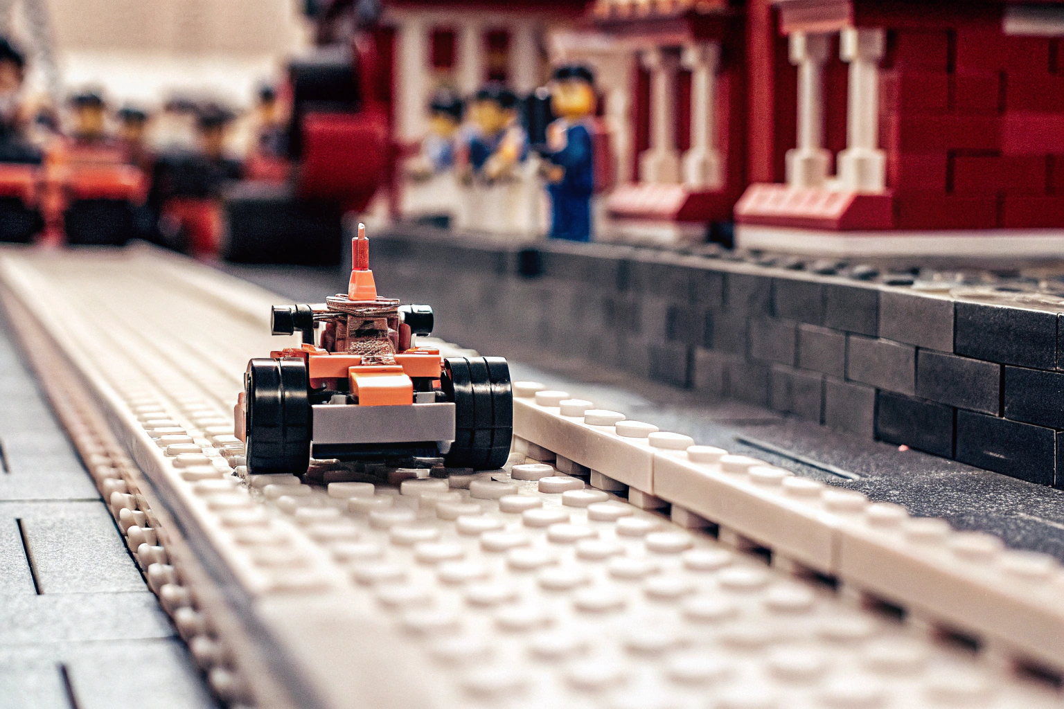 Eine Nahaufnahme des LEGO Speed Champions McLaren Formel 1 Rennwagens auf einer improvisierten Rennstrecke. LEGO Speed Champions McLaren Formel 1