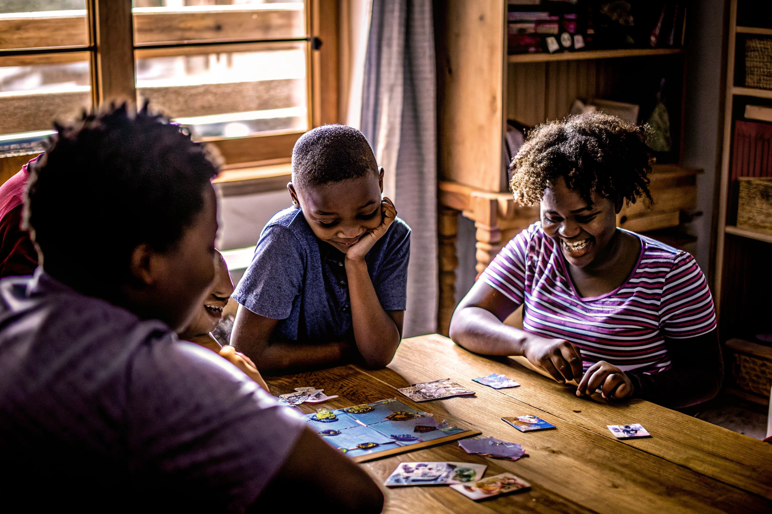 Kinder spielen ein Brettspiel am Tisch, lachen und haben Spaß. Kinder spielen Brettspiel