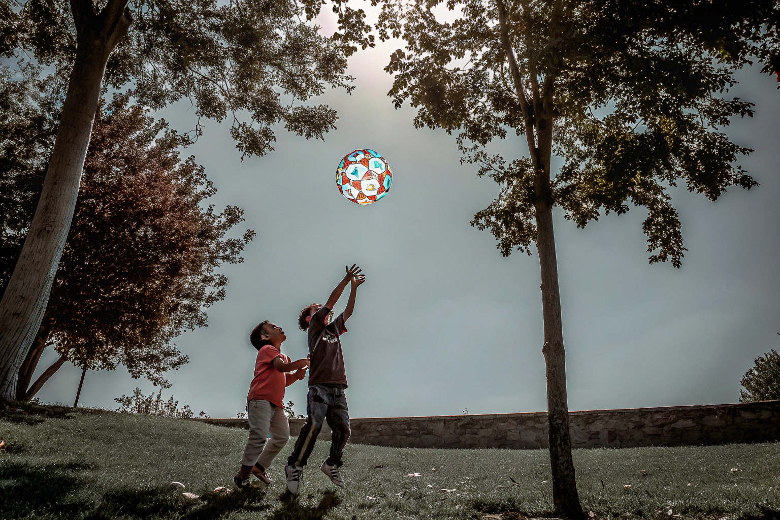 Kinder spielen mit dem semai Fliegenden Ball im Freien, der Ball leuchtet in bunten LED-Farben. Kinder spielen mit dem semai Fliegenden Ball