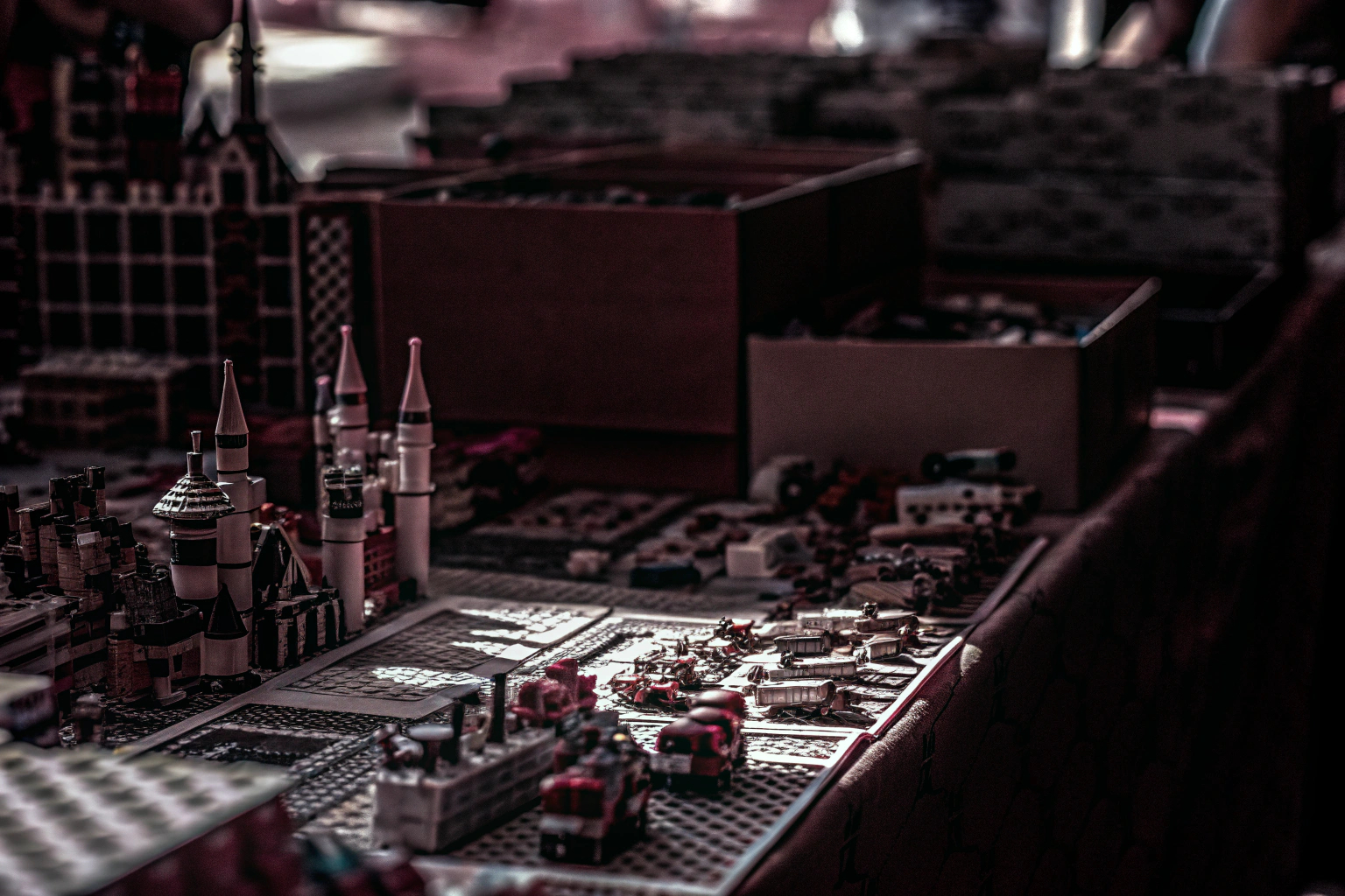 Verschiedene LEGO-Sets, die auf einem Tisch ausgebreitet sind, umgeben von begeisterten Kindern und Erwachsenen. Verschiedene LEGO-Sets auf einem Tisch